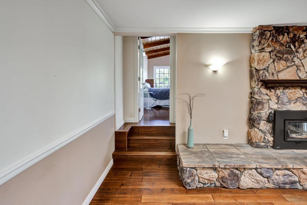 11985 Rocoso Road Lakeside, CA 92040 - Photo 17 of 48 a view of a hallway with wooden floor and a fireplace