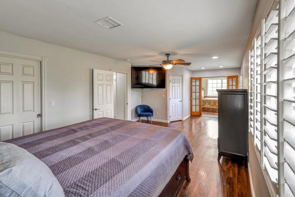 11985 Rocoso Road Lakeside, CA 92040 - Photo 20 of 48 a bedroom with a bed and a fireplace with wooden floor