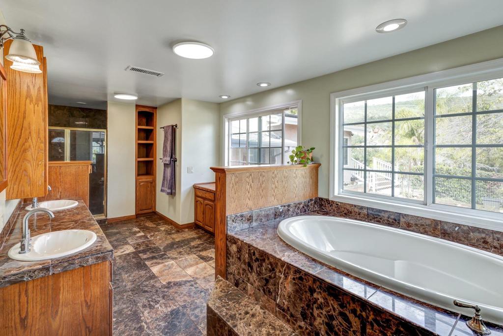 11985 Rocoso Road Lakeside, CA 92040 - Photo 24 of 48 a bathroom with a granite countertop tub sink and mirror
