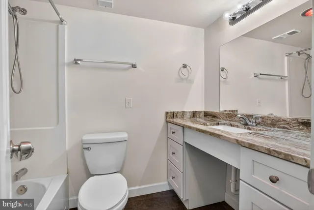 a bathroom with a granite countertop sink toilet and shower