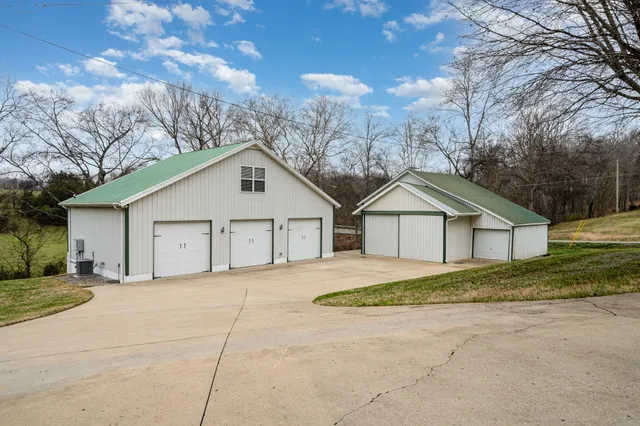 a view of house with a yard and large trees