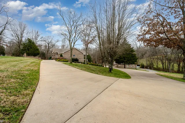 an aerial view of a house with a garden and lake view