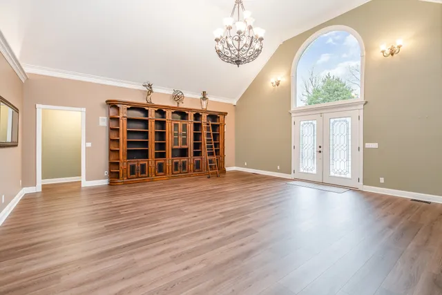 a view of a dining room with furniture a chandelier and wooden floor