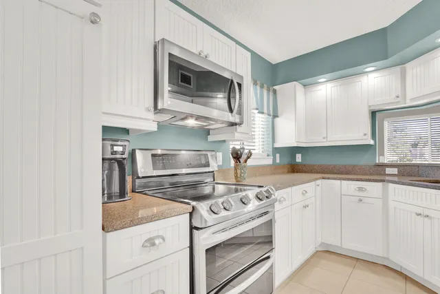 a kitchen with white cabinets stainless steel appliances and sink