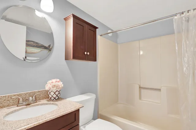 a bathroom with a granite countertop sink toilet and shower