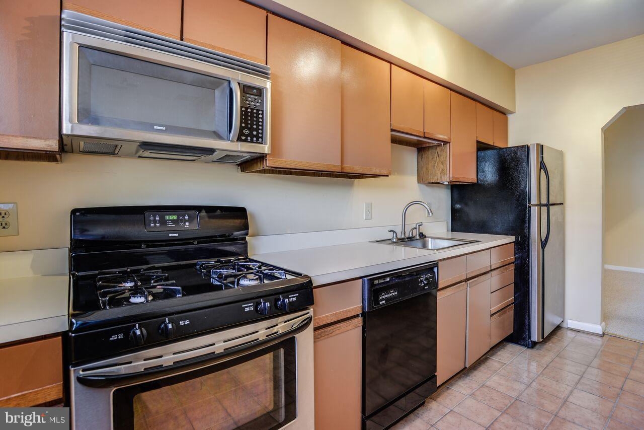 204 Skyhill Road, Unit 7 Alexandria, VA 22314 - Photo 12 of 20 a kitchen with stainless steel appliances granite countertop a stove microwave and refrigerator