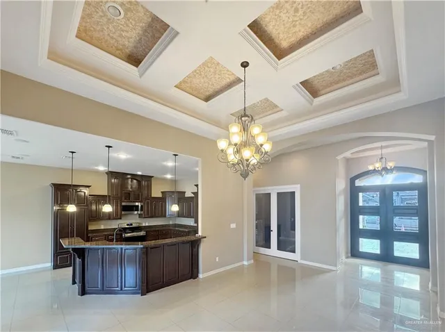 a large kitchen with kitchen island a large counter space a sink stainless steel appliances and cabinets