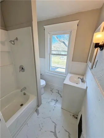 a bath room with a toilet and a bath tub