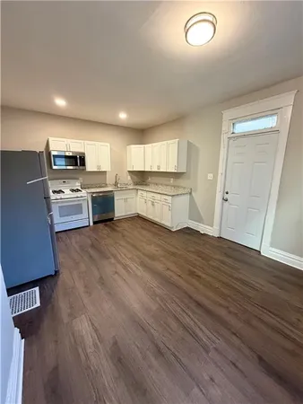 a kitchen with a refrigerator microwave and stove top oven