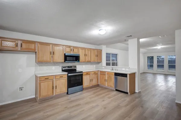 a kitchen with granite countertop a stove top oven and sink