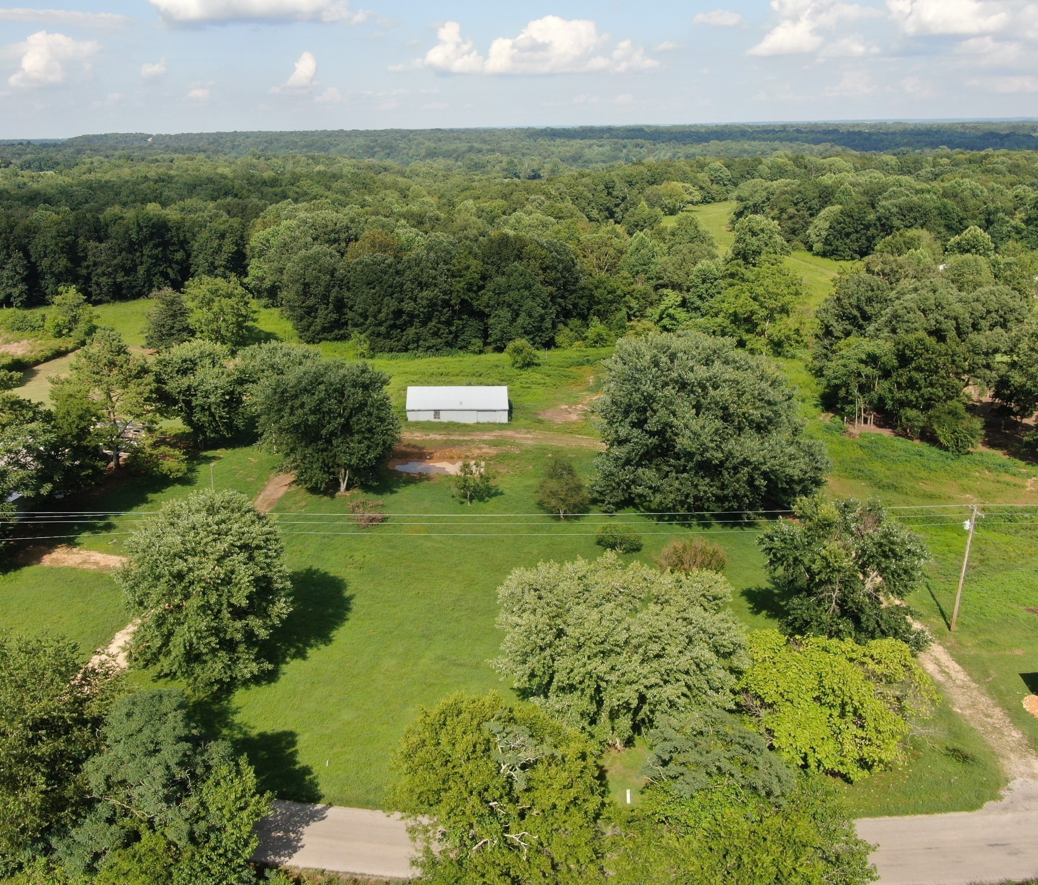 1075 Rose Hill Road Pulaski, TN 38478 - Photo 1 of 11 a view of a garden with a building in the background