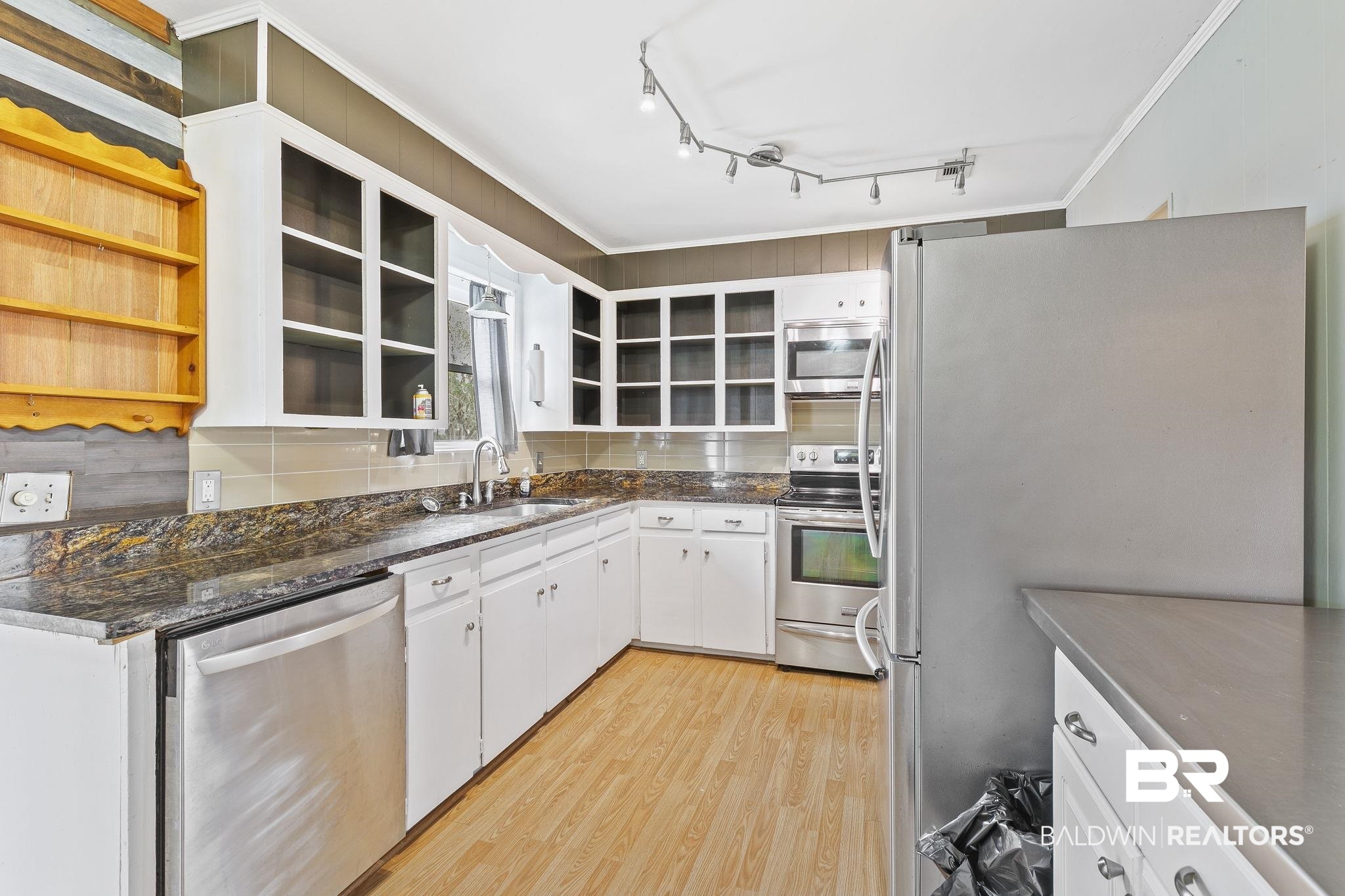 13108 6th Street Lillian, AL 36549 - Photo 13 of 39 Kitchen with stainless steel appliances, backsplash, sink, white cabinets, and light hardwood / wood-style floors