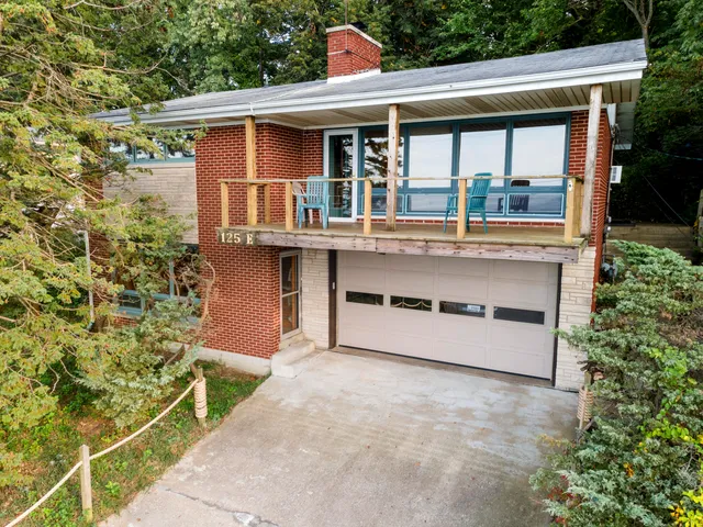 a front view of a house with a garden and balcony