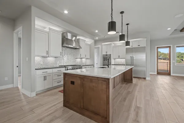 a kitchen with granite countertop cabinets stainless steel appliances and wooden floor