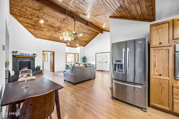 a kitchen with stainless steel appliances granite countertop a refrigerator a sink dishwasher a stove and a refrigerator with wooden floor