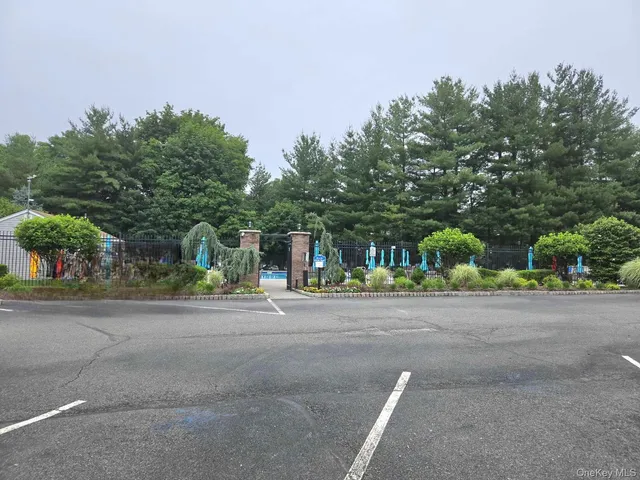 a backyard of a house with table and chairs plants and large trees