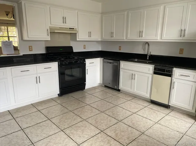 a kitchen with granite countertop white cabinets and black appliances