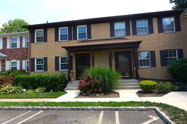 a front view of a house with yard and green space