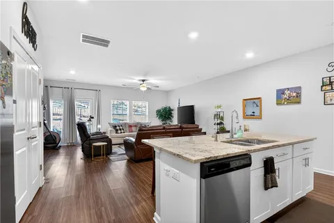 a open kitchen with stainless steel appliances granite countertop a stove and chairs