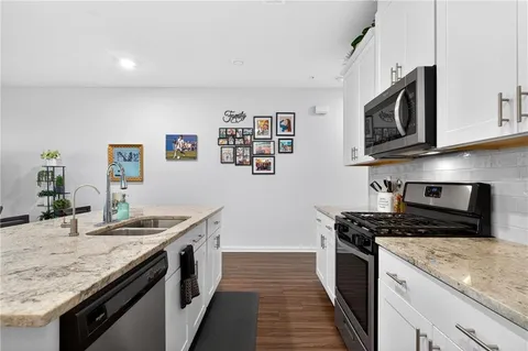 a kitchen with stainless steel appliances granite countertop a sink stove and microwave