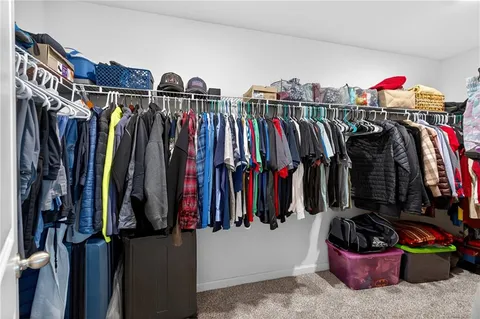 a walk in closet with clothes