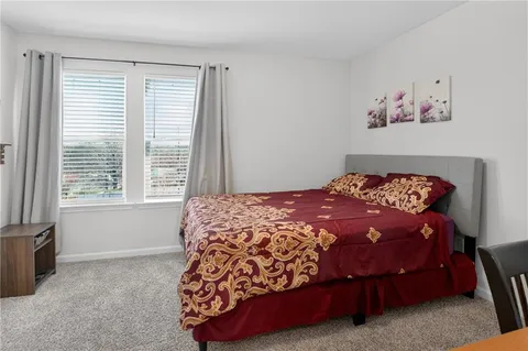 a bed sitting in a bedroom next to a window