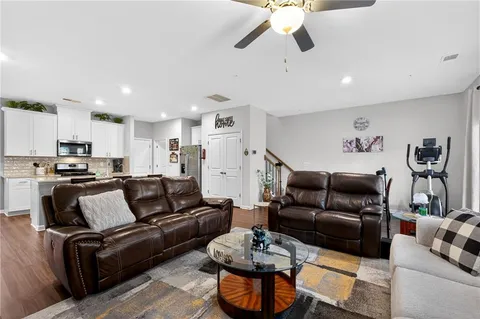 a view of living room kitchen with furniture and a ceiling fan