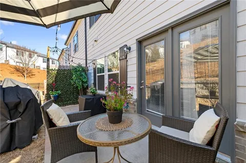 a dining room with furniture a rug and a potted plant