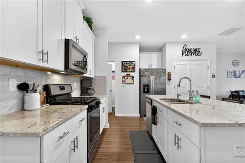 a kitchen with stainless steel appliances granite countertop a sink stove and refrigerator
