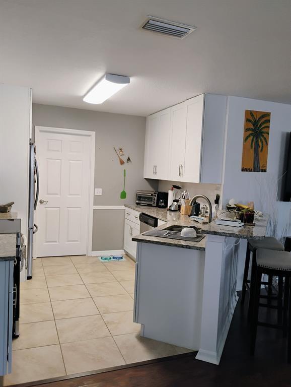 14441 Dulce Real Avenue Fort Pierce, FL 34951 - Photo 22 of 23 a kitchen with stainless steel appliances granite countertop a sink and cabinets