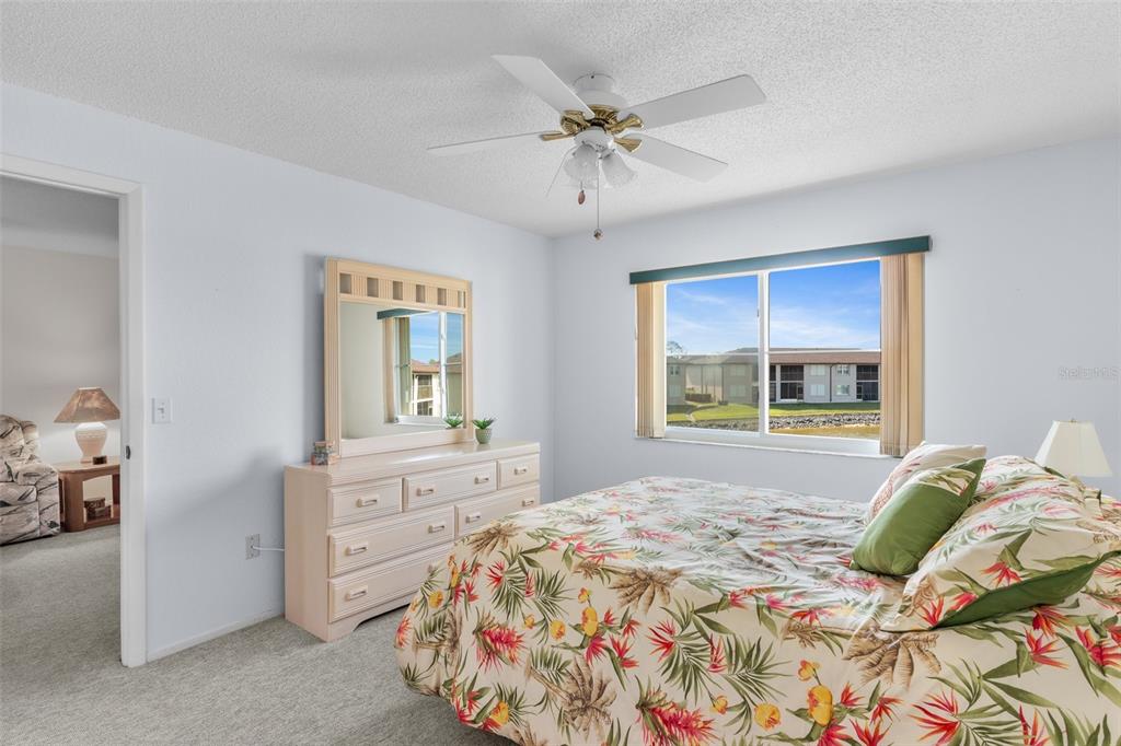 25100 Sandhill Boulevard, Unit R202 Punta Gorda, FL 33983 - Photo 15 of 39 a bedroom with a bed and a chandelier