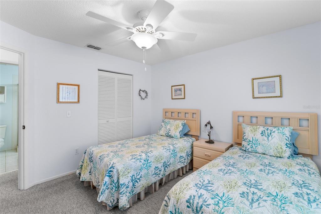 25100 Sandhill Boulevard, Unit R202 Punta Gorda, FL 33983 - Photo 22 of 39 a bedroom with two beds and a chandelier