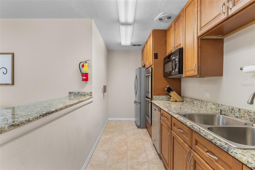 25100 Sandhill Boulevard, Unit R202 Punta Gorda, FL 33983 - Photo 31 of 39 a kitchen with granite countertop a sink a stove and cabinets