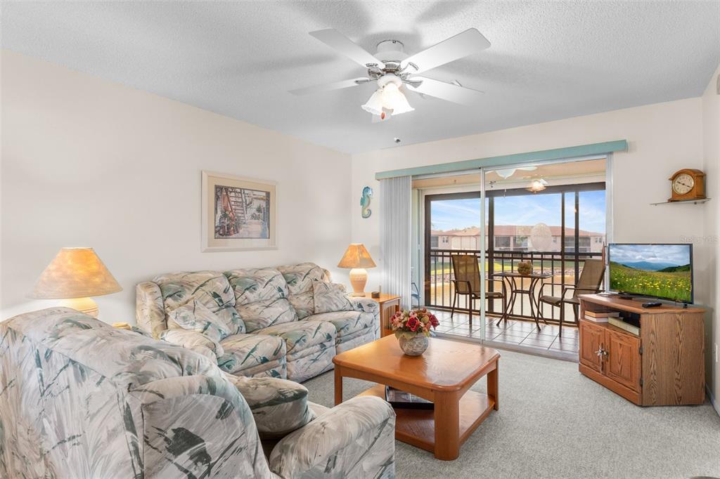 25100 Sandhill Boulevard, Unit R202 Punta Gorda, FL 33983 - Photo 9 of 39 a living room with furniture and a flat screen tv