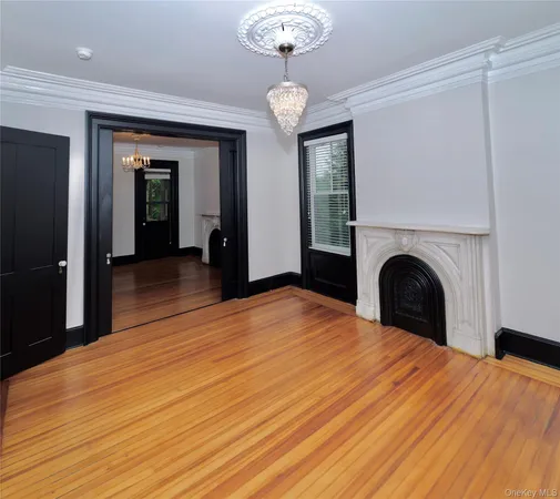 a view of a livingroom with a chandelier fireplace and a window