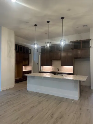 a view of a living room and kitchen with granite countertop wooden floor