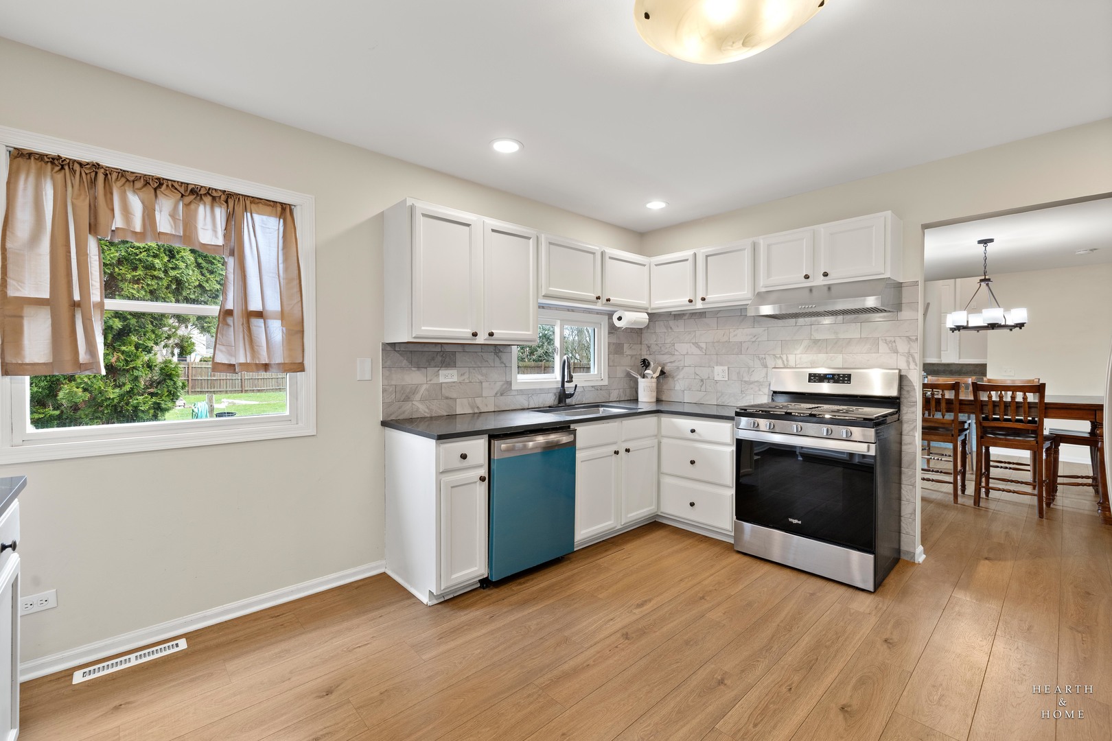 831 Chestnut Court Marengo, IL 60152 - Photo 12 of 29 a kitchen with granite countertop wooden floors stainless steel appliances and sink