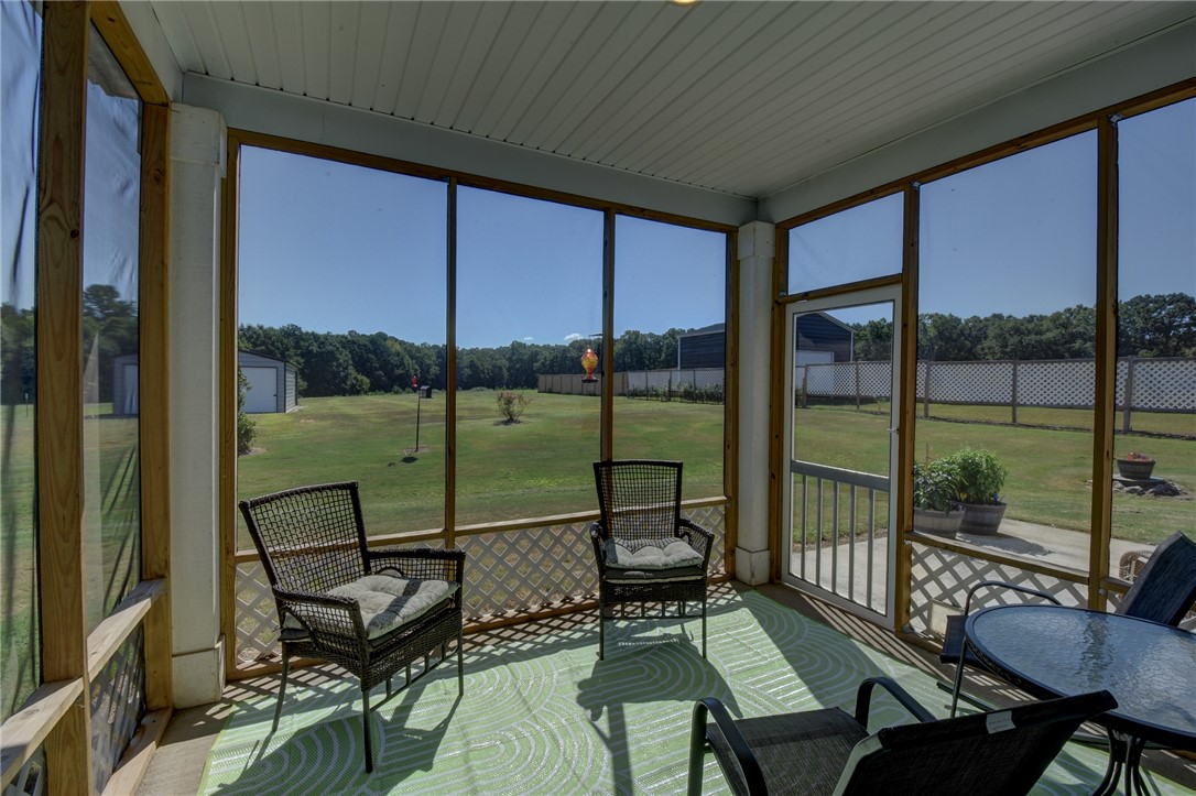 220 Clinkscales Road Anderson, SC 29624 - Photo 13 of 33 An inviting screened porch overlooks a grassy yard framed by mature trees.
