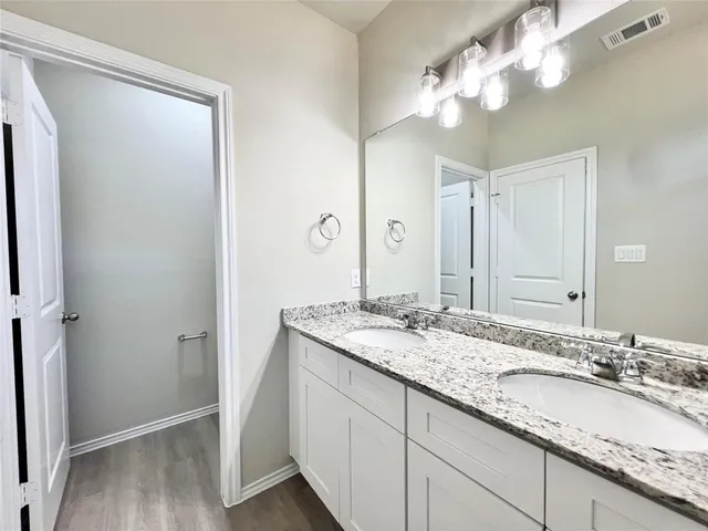 a bathroom with a double vanity sink and a mirror