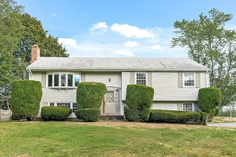 a front view of a house with a yard and potted plants