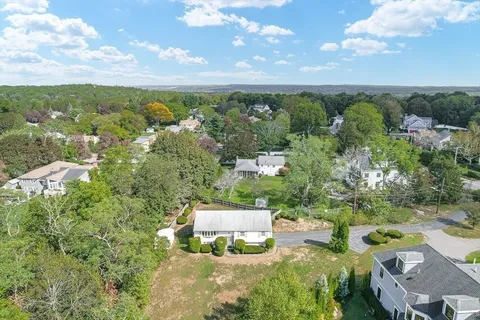 an aerial view of residential houses with outdoor space and trees