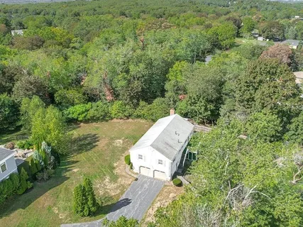 an aerial view of a house with a yard and lake view
