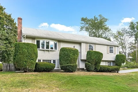 a front view of a house with a yard and potted plants