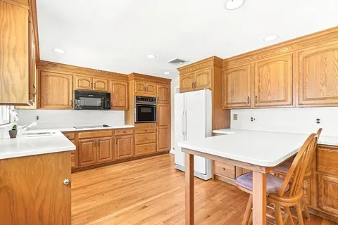 a kitchen with stainless steel appliances cabinets and wooden floor
