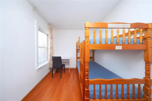 a bedroom with a bed and wooden floor