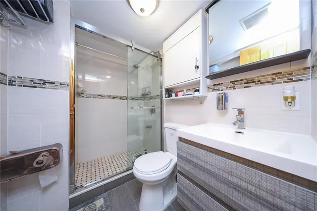 a bathroom with a sink a toilet and shower
