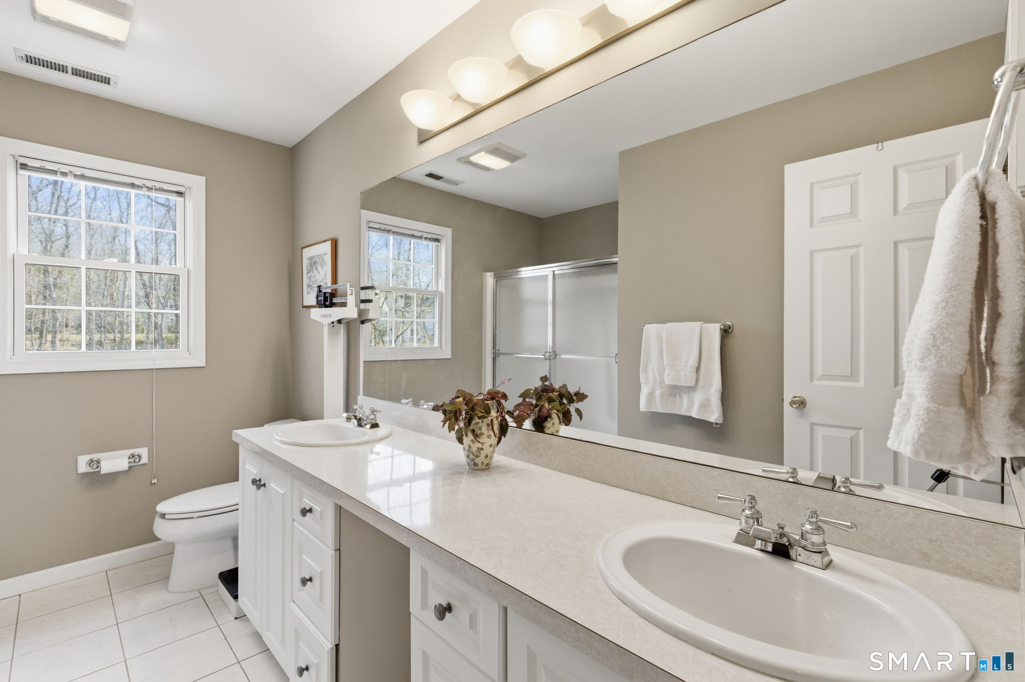 22 Misty Vale Road Newtown, CT 06482 - Photo 14 of 30 a bathroom with double vanity sinks a toilet a mirror and a window