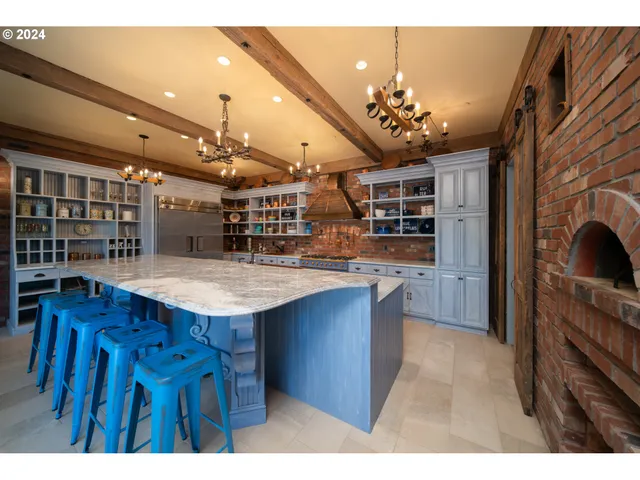a open kitchen with stainless steel appliances kitchen island granite countertop a table and chairs