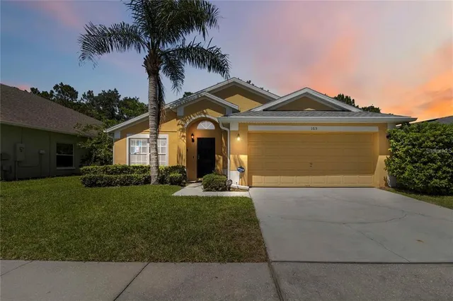 a front view of a house with a garden and yard