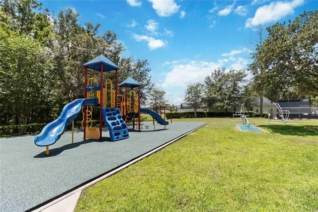 a view of a swimming pool with a bench and trees in the background